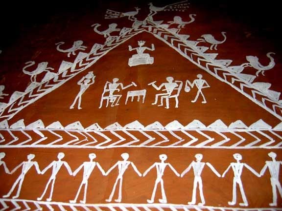 Traditional white-on-red tribal wall painting of villagers and animals