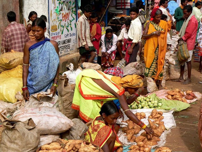 Tribal women trading sweet potatoes and vegetables at a weekly market in southern Odisha